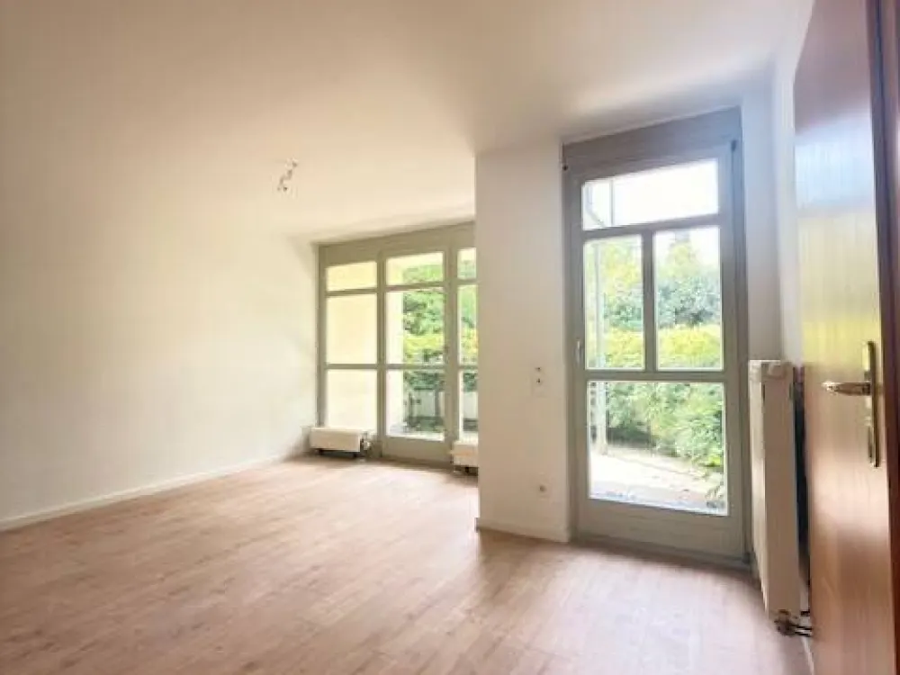 Einzigartige Chance - charmante Singlewohnung mit Einfamilienhauscharme am Stadtrand - Wohnzimmer mit unverbautem Blick ins Grüne und Sonnenterrasse
